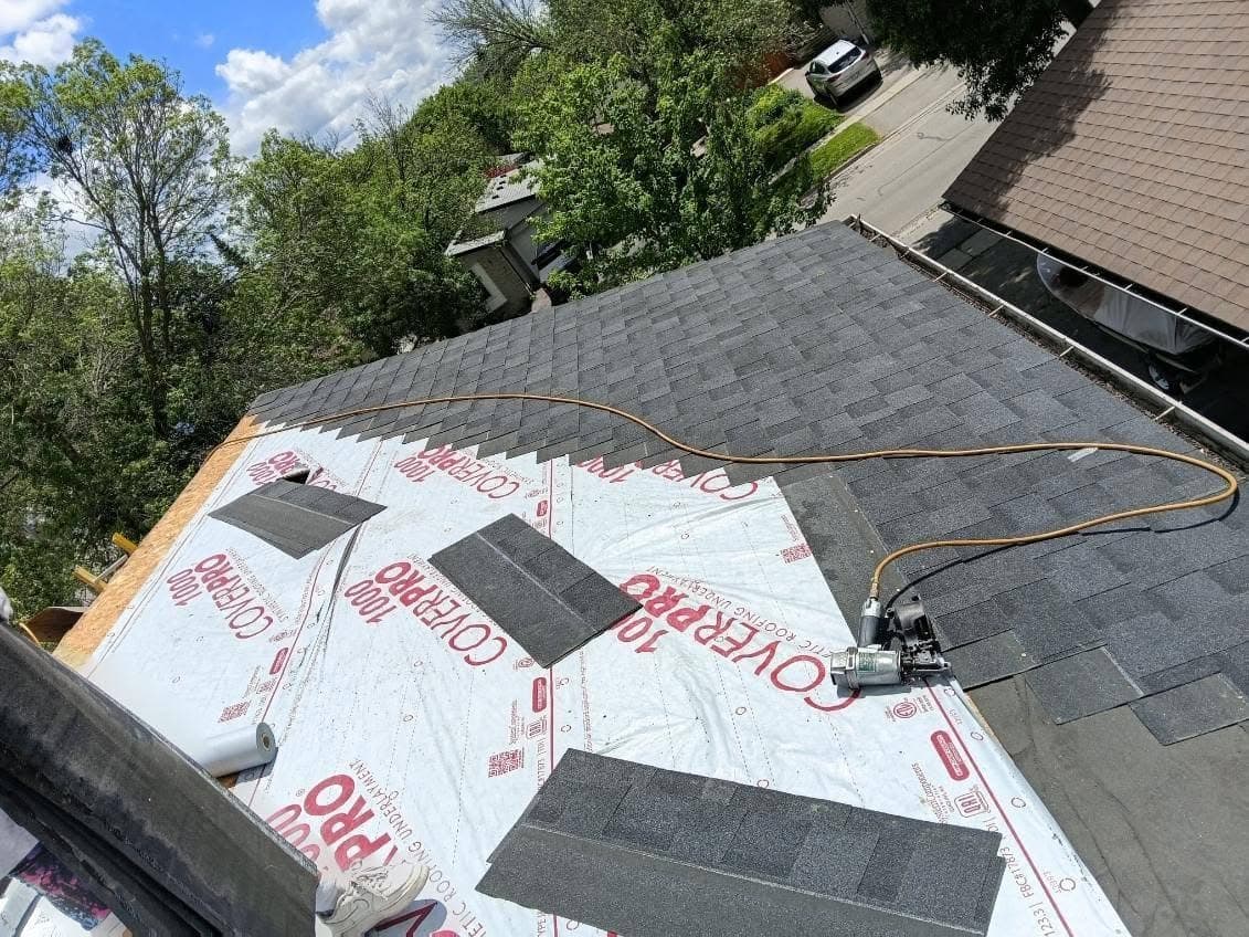 New underlayment being installed over fresh roof decking